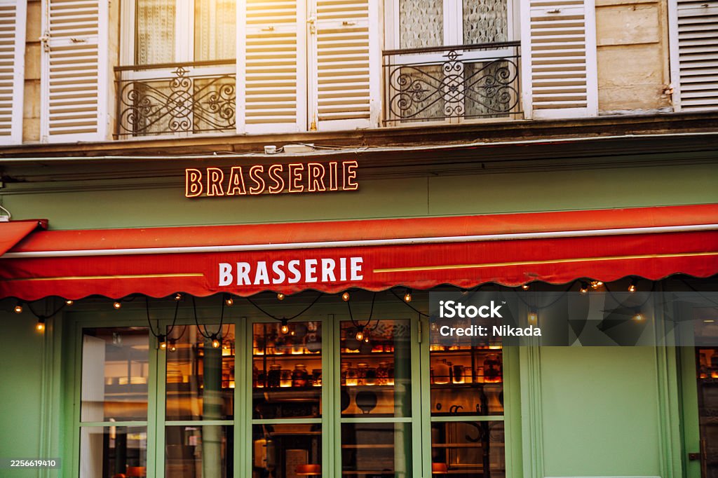 Brasserie avec store banne rouge et lambrequin marqué — terrasse ombragée après rentoilage